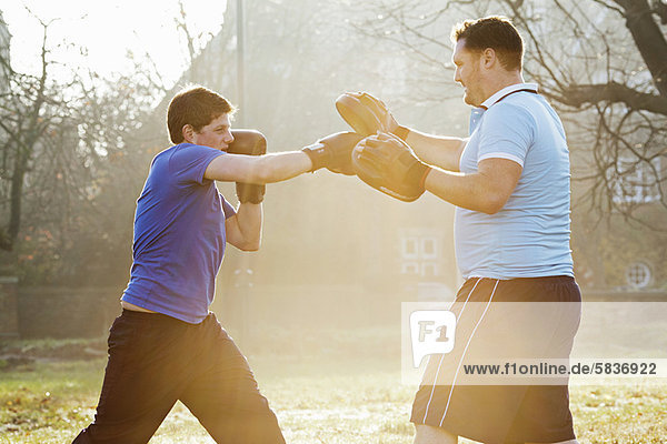 Boxer training with coach outdoors