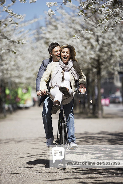 Mann fährt mit Freundin auf dem Fahrrad
