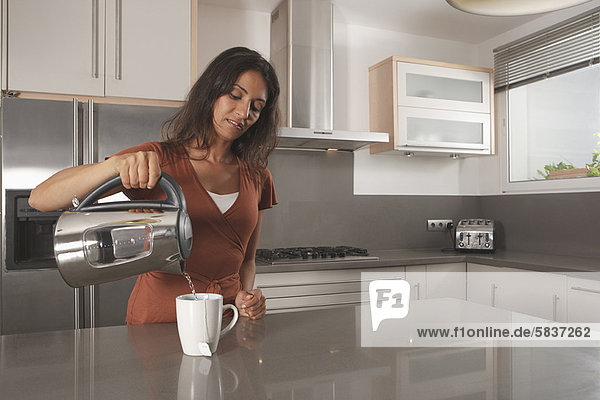 Frau macht eine Tasse Tee in der Küche