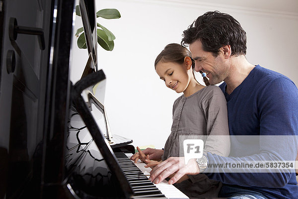 Vater und Tochter spielen Klavier