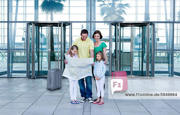 Family with map outside airport