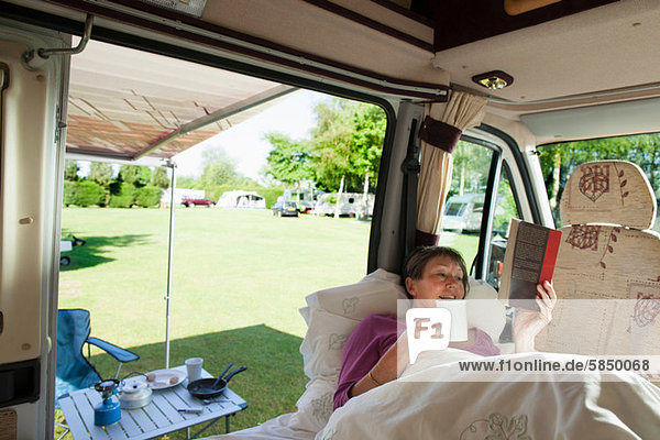 Mature woman reading in camper van