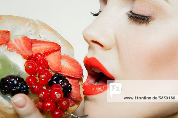 Junge Frau  die frisches Obst isst  Mund