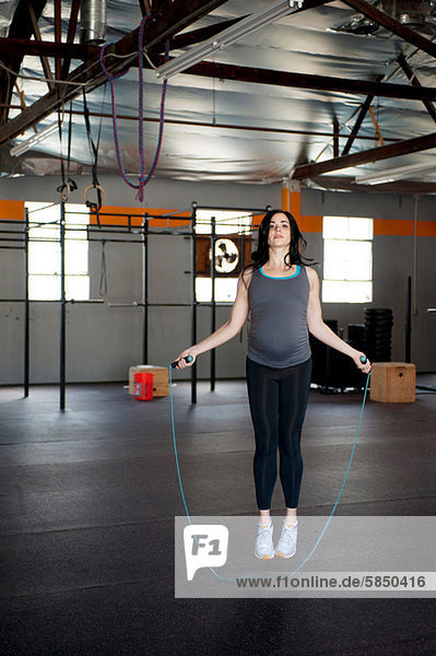 Schwangere junge Frau  die mit Seil springt