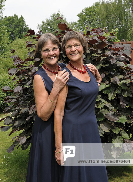 Zwei rüstige Zwillingsschwestern  gleich gekleidet