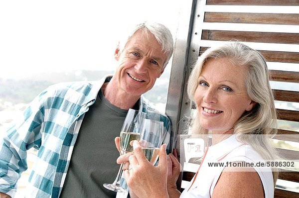 Porträt eines ausgereiften Paares hält Champagne Flöten und lächelnd