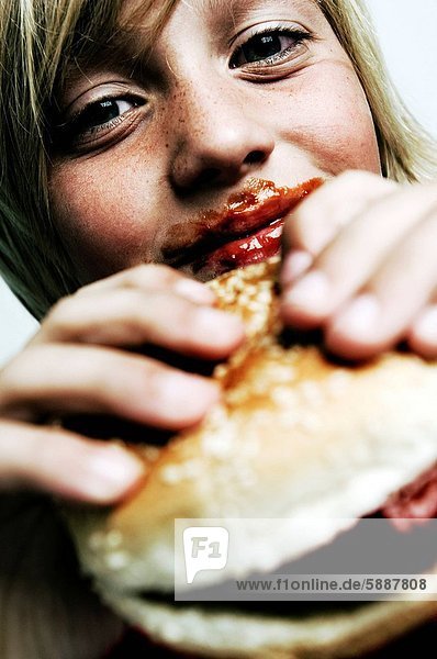 Close_up of a boy holding a burger