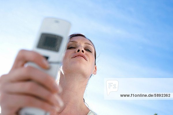 Low angle view of a young woman holding a mobile phone