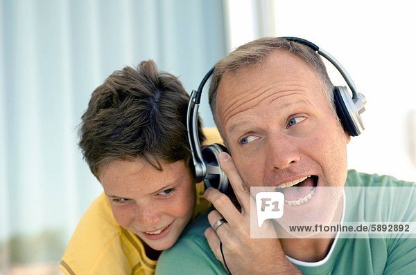 hinter Mann zuhören lächeln Sohn Kopfhörer Musik reifer Erwachsene reife Erwachsene Kleidung Klassisches Konzert Klassik