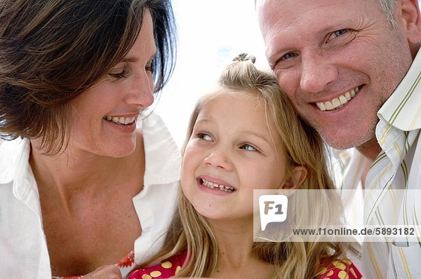 Close_up of a mid adult couple and their daughter smiling