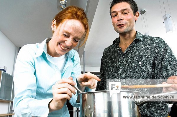Close_up of a mid adult couple cooking food in the kitchen