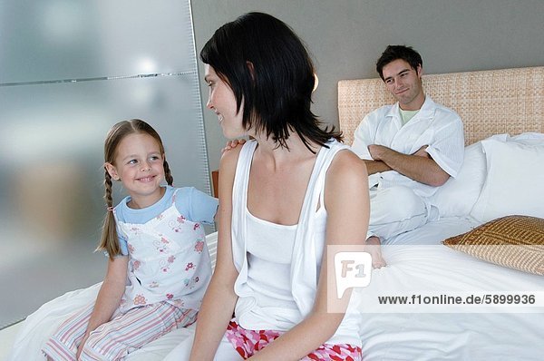 sitzend Frau lächeln Bett Hintergrund Mittelpunkt Tochter Erwachsener Ehemann
