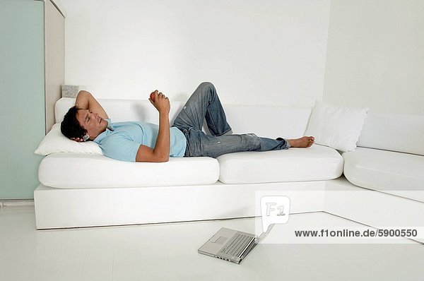 Profil  Profile  liegend  liegen  liegt  liegendes  liegender  liegende  daliegen  Mann  halten  Mittelpunkt  Couch  Apfel  Seitenansicht  Erwachsener