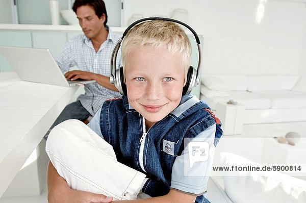 benutzen  Portrait  zuhören  Notebook  Junge - Person  Menschlicher Vater  Kopfhörer  Hintergrund  Musik  Kleidung