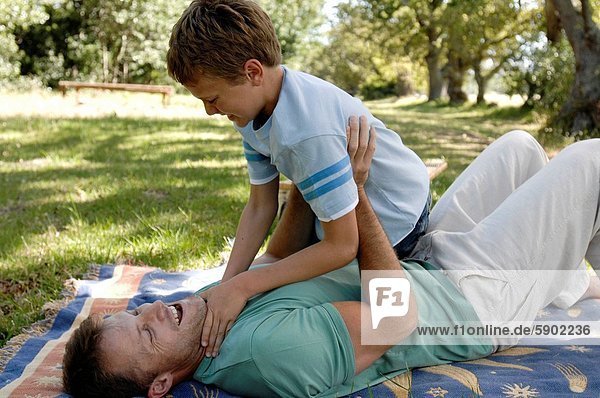 Side profile of a mid adult man playing with his son in a park