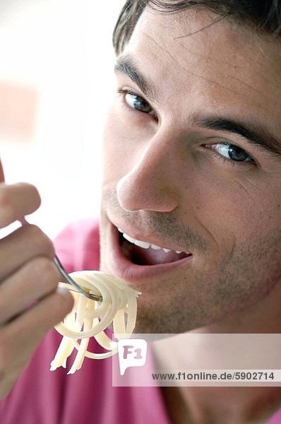 Portrait Mann jung Spaghetti essen essend isst