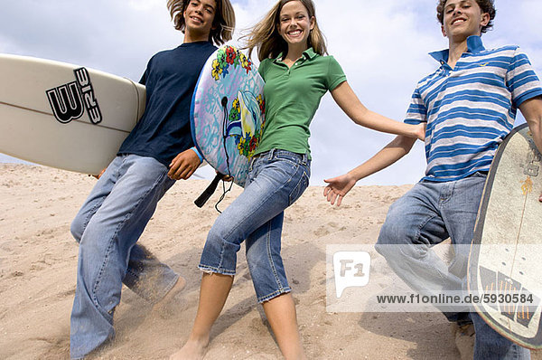 niedrig  Jugendlicher  gehen  Strand  Junge - Person  halten  Surfboard  Ansicht  2  Flachwinkelansicht  Mädchen  Winkel