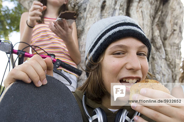 hinter  Portrait  Jugendlicher  Junge - Person  halten  Schokolade  essen  essend  isst  cupcake  Mädchen