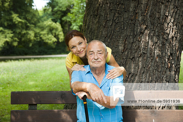 Woman with old man on park bench