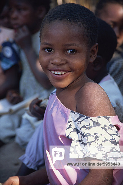 Head and shoulders portrait of girl smiling and looking at the camera Mozambique Africa