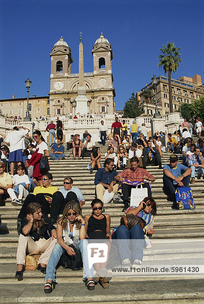 Gruppen von Touristen sitzen auf der spanischen Treppe mit der Trinite dei Monti hinter  in Rom  Lazio  Italien  Europa
