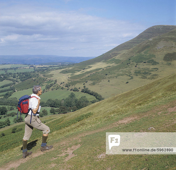 Man ascending Y Grib with Mynydd Bychan in the background  The Black Mountains  Powys  Wales  United Kingdom  Europe