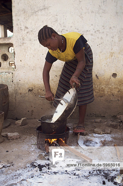 Porträt einer Frau  die Kochen im freien über ein kleines Feuer  Gambia  Westafrika  Afrika