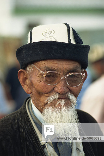 Portrait of an old Kirghiz man with white beard  felt hat and glasses at the horse market at Balikchi in Kyrgyzstan  Central Asia  Asia