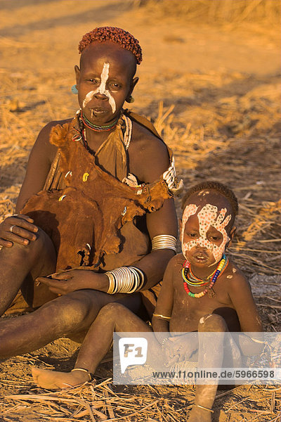 Karo woman with child wearing traditional goatskin dress decorated with cowrie shells  Kolcho village  Lower Omo Valley  Ethiopia  Africa