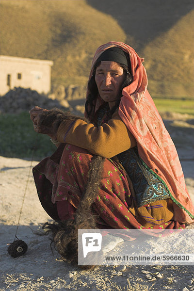 Alte Dame mit tätowierten Gesicht sitzen Spinnen Wolle von Karawanserei  Daulitiar  zwischen Yakawlang und Chakhcharan  Afghanistan  Asien