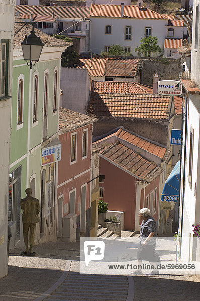 Eine ältere Frau geht über die Straße in Monchique  Algarve  Portugal  Europa