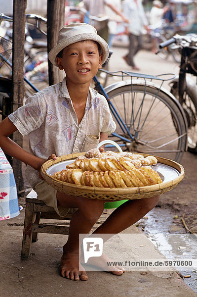 Bildnis eines Knaben verkaufen süße Kuchen auf dem Bürgersteig in der Stadt von Rach Gia in das Mekong-Delta  Vietnam  Indochina  Südostasien  Asien