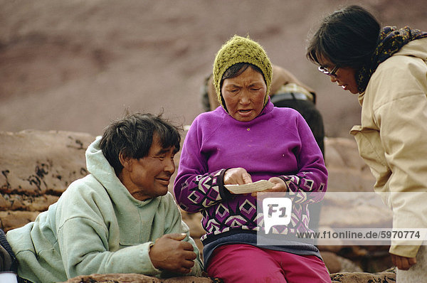 Nahaufnahme von drei Menschen  darunter eine Frau im Kammgarn Hut  Lesen aus einem Stück Papier  in Grönland  Polarregionen