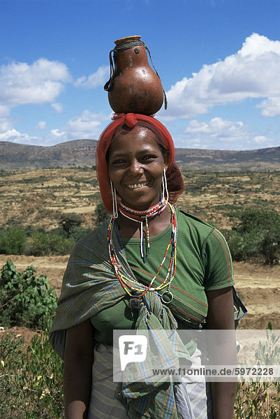Bunten lokalen Frau mit Perlen tragen ein Kürbis auf ihrem Kopf  ethnisch  Äthiopien  Afrika