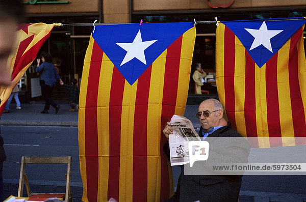 Reading the newspaper under the Catalan flag on La Rambla  Barcelona  Catalonia  Spain  Europe