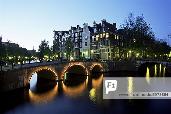 Grachten  beleuchteten Brücken und traditionelle Gebäude bei Nacht  Amsterdam  Holland  Europa