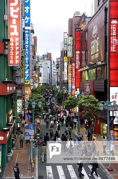Eine Fußgängerzone gesäumt von Geschäften und Schilder zieht eine Menge in Shinjuku Tokio Japan Asien