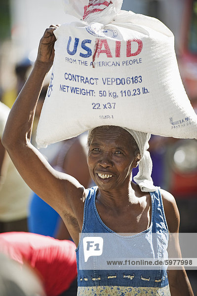 Eine Frau mit Reis  USAid Verteilung der Lebensmittel nach dem Januar 2010 Erdbeben von Port au Prince  Haiti  West Indies  Karibik  Mittelamerika