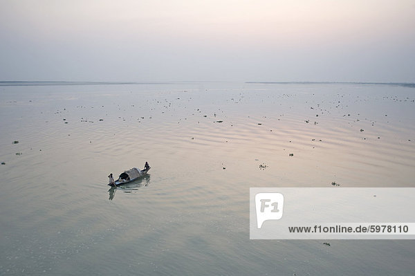 Zwei Fischer am Boot im Morgengrauen auf dem Brahmaputra River  Assam  Indien  Asien