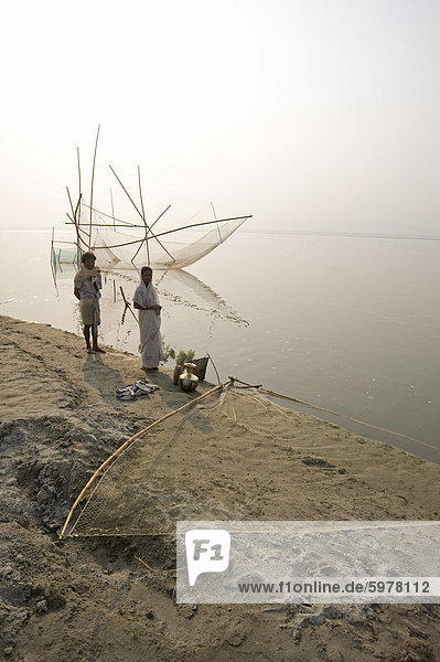 Fisherman and his wife at the rivers edge with nets  Brahmaputra River  Assam  India  Asia
