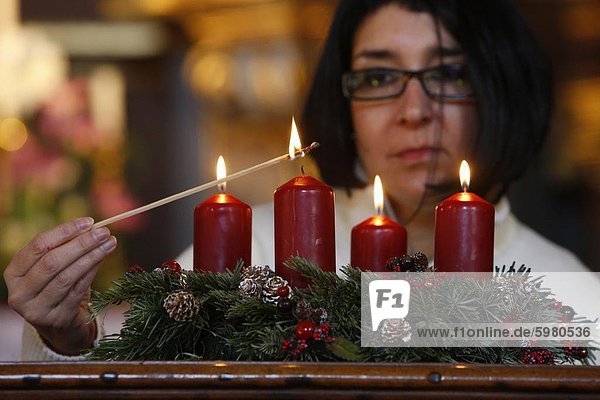Woman lighting Advent candles  Saint-Nicolas de Veroce  Haute Savoie  France  Europe