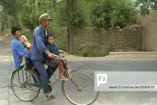 Family riding on a bicycle in Ningxia  China  Asia