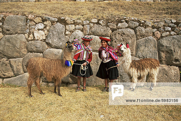 Einheimische Frauen und Lamas vor Inka-Ruinen  in der Nähe von Cuzco  Peru  Südamerika