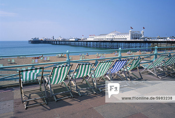 Liegestühle oberhalb des Strandes und der Palace Pier in Brighton  Sussex  England  Vereinigtes Königreich  Europa