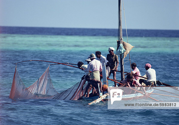 Crowded fishing boat raising its nets  Maldives  Indian Ocean  Asia
