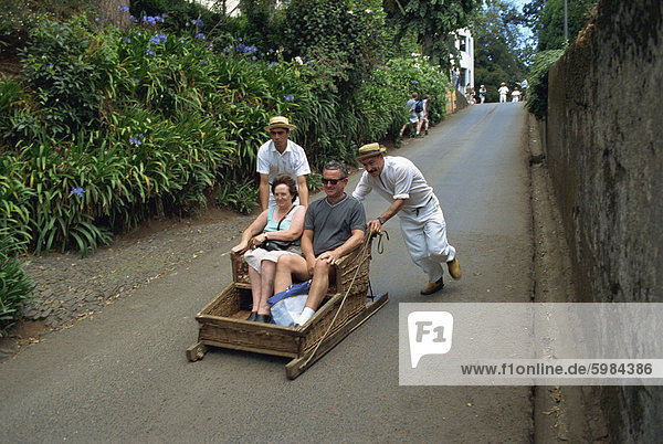 Touristen auf Schlitten fahren bergab am Monte  Madeira  Portugal  Europa
