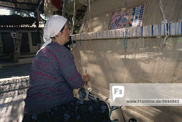 Woman weaving wool carpet on a loom in a workshop at Kusadasi  Anatolia  Turkey  Asia Minor  Eurasia