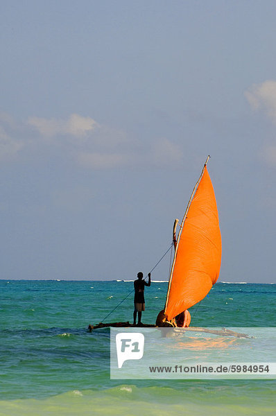 Eine traditionelle Holzdau mit einer orange Segel  Paje  Zanzibar  Tansania  Ostafrika  Afrika
