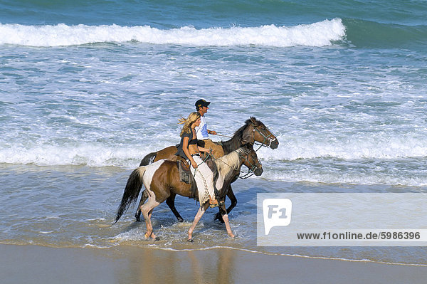 Couple riding horses on the beach  Tibau do Sul  Natal  Rio Grande do Norte state  Brazil  South America