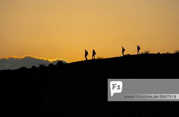 People walking at sunset on top of White House Cliffs  Red Rock Canyon State Park  California  United States of America  North America